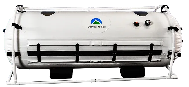 The Dive, a white Summit to Sea chamber lying on its side in a white frame.