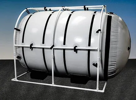 The Grand Dive Pro Plus, a very large white Summit to Sea chamber in a white frame.
