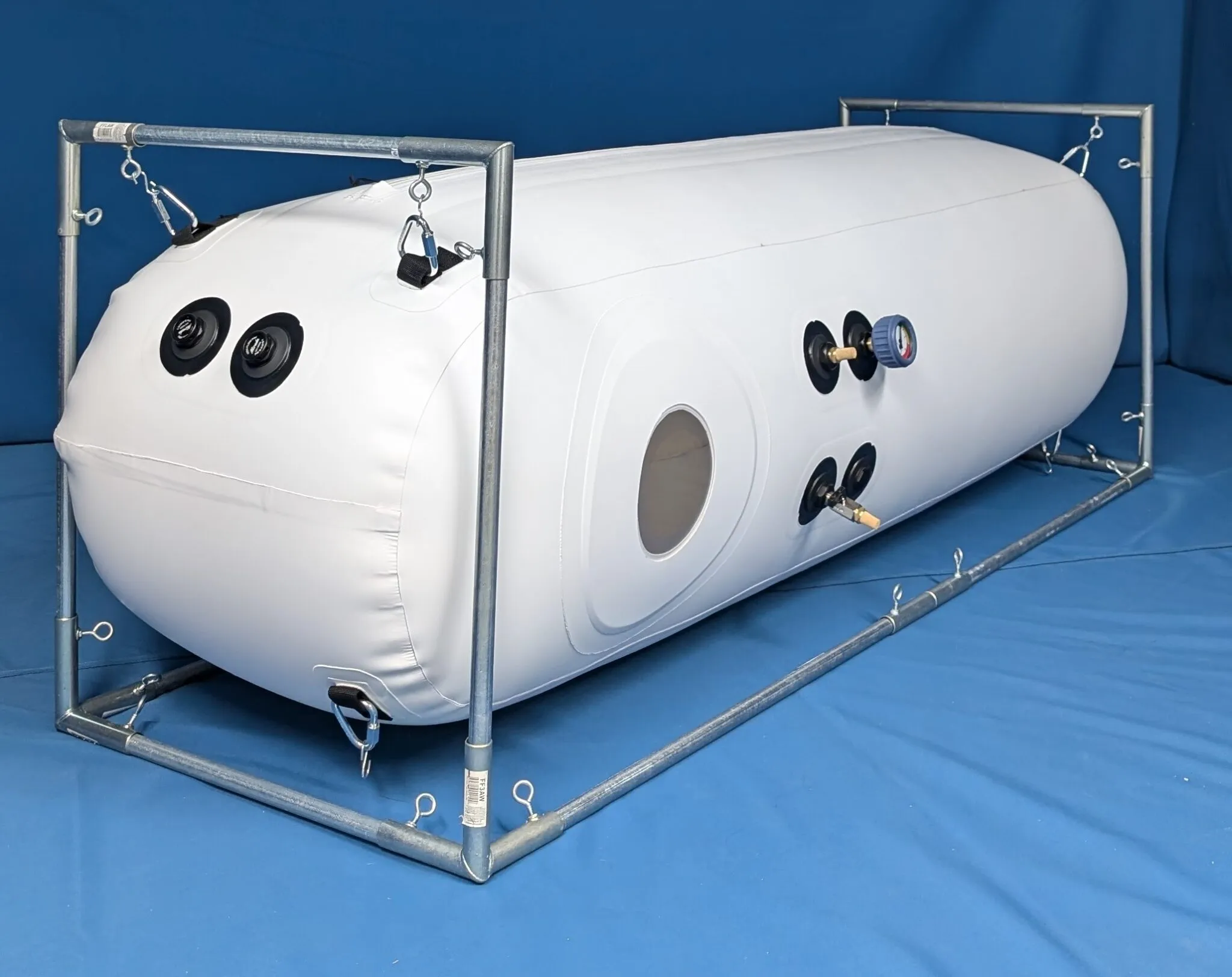 A slim white Newtowne lay down chamber with one window, in a steel frame.